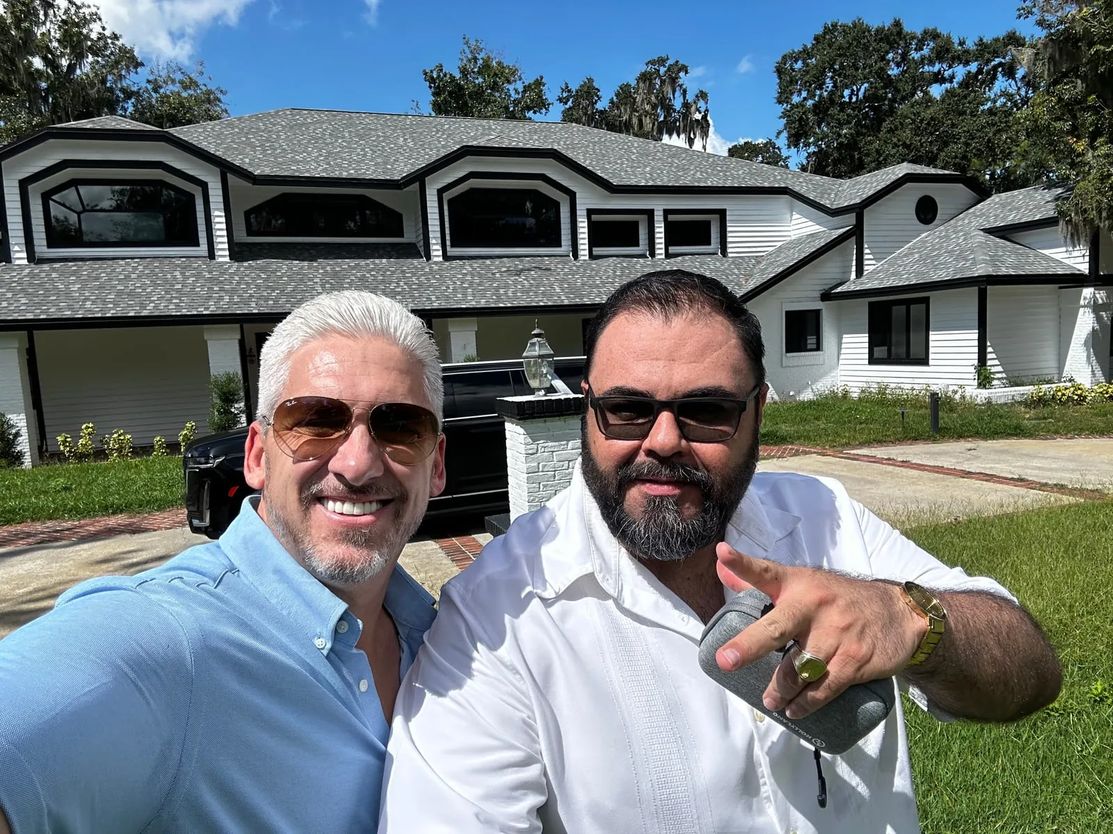 Chad McCall with a partner outside a large renovated home
